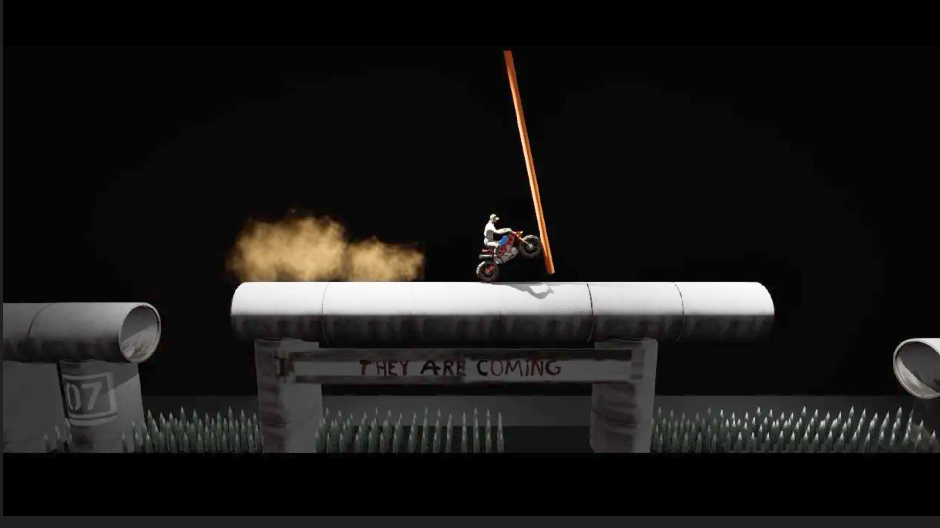 A trials motorcycle rider crosses a row of large concrete pipes in an industrial setting.